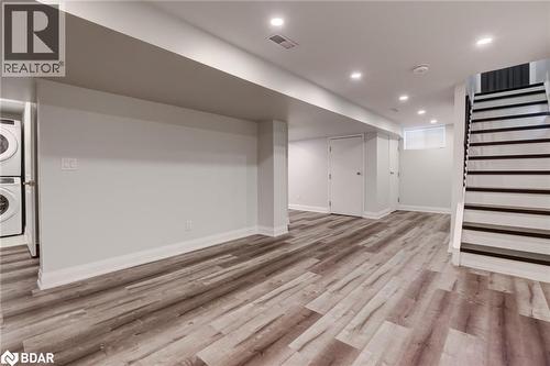 Finished below grade area featuring recessed lighting, stairs, light wood-style flooring, and estacked washer and dryer - 22 St James Street Unit# C, Brantford, ON - Indoor Photo Showing Other Room