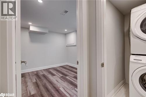 Washroom with stacked washer / dryer, light wood-type flooring, and recessed lighting - 22 St James Street Unit# C, Brantford, ON - Indoor Photo Showing Laundry Room