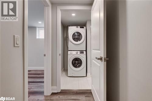 Laundry area with stacked washing machine and dryer and light wood finished floors - 22 St James Street Unit# C, Brantford, ON - Indoor Photo Showing Laundry Room
