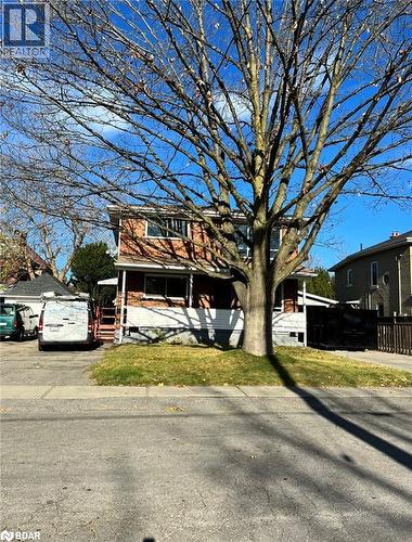 View of property hidden behind natural elements with a front lawn - 22 St James Street Unit# C, Brantford, ON - Outdoor