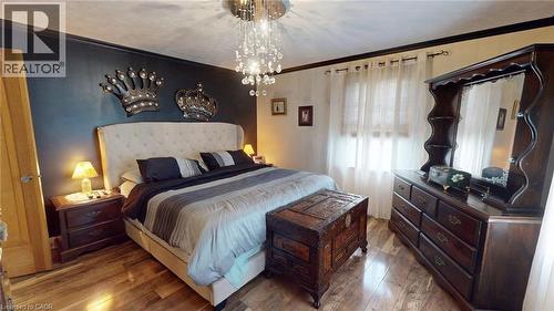 Bedroom with crown molding, wood finished floors, and a chandelier - 113 Edmund Road, Kitchener, ON - Indoor Photo Showing Bedroom