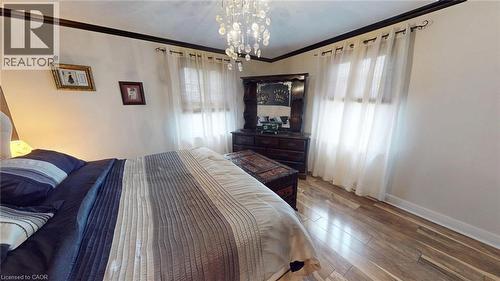 Bedroom featuring ornamental molding, hardwood / wood-style floors, and a chandelier - 113 Edmund Road, Kitchener, ON - Indoor Photo Showing Bedroom