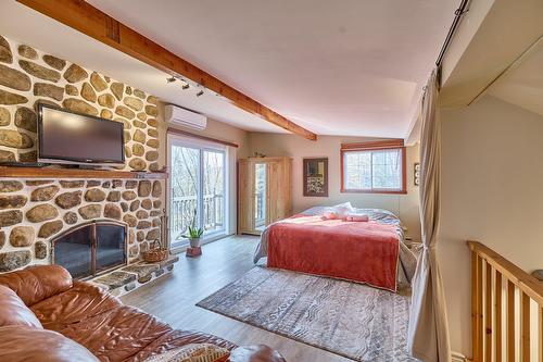 Chambre à coucher principale - 79 Ch. Vaillancourt, Saint-Donat, QC - Indoor Photo Showing Bedroom With Fireplace