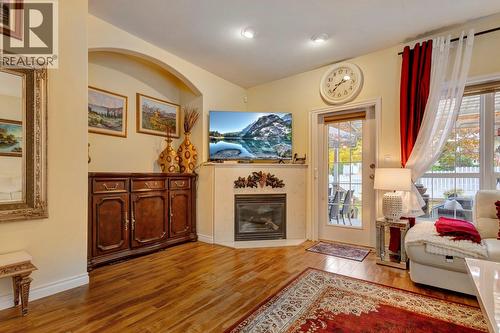Cozy fireplace in the living room with 1 of 2 direct access points to the yard - 393 Mccarren Avenue, Kelowna, BC - Indoor Photo Showing Living Room With Fireplace