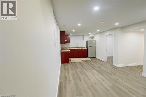 Kitchen with recessed lighting, light countertops, freestanding refrigerator, light wood-style floors, and dark brown cabinets - 19 Sassafras Street Unit# Lower, Kitchener, ON - Indoor