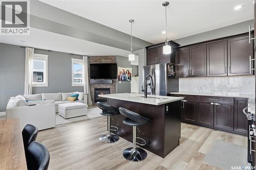 17 600 Maple Crescent, Warman, SK - Indoor Photo Showing Kitchen With Fireplace With Stainless Steel Kitchen With Upgraded Kitchen