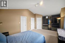 Carpeted bedroom with lofted ceiling and baseboards - 