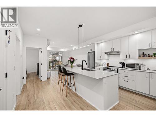 Light Oak Hardwood style flooring throughout the condo. - 660 Cawston Avenue Unit# 313, Kelowna, BC - Indoor Photo Showing Kitchen With Double Sink With Upgraded Kitchen