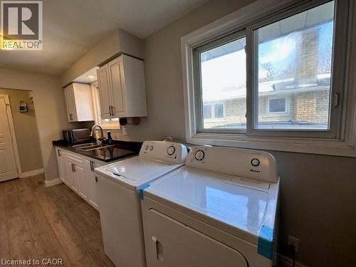 Laundry room with dark wood finished floors, washer and clothes dryer, and cabinet space - 121 Roberts Crescent Unit# Upper, Kitchener, ON - Indoor Photo Showing Other Room