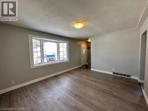 Empty room with dark wood-style floors and a textured ceiling - 121 Roberts Crescent Unit# Upper, Kitchener, ON - Indoor Photo Showing Other Room