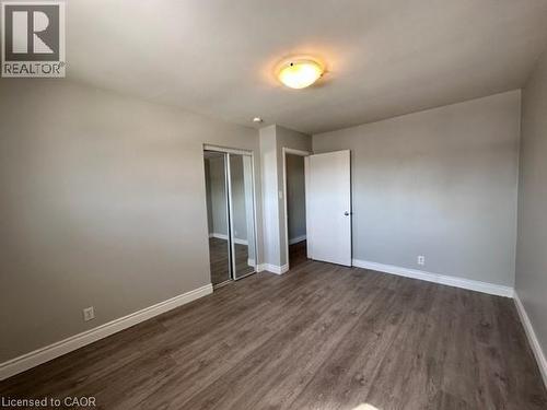 Unfurnished bedroom featuring dark wood-style flooring and a closet - 121 Roberts Crescent Unit# Upper, Kitchener, ON - Indoor Photo Showing Other Room
