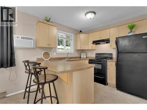 Kitchen with Bar Seating - 588 Mccurdy Road, Kelowna, BC - Indoor Photo Showing Kitchen With Double Sink