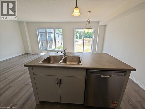Kitchen with dishwasher, dark wood-type flooring, decorative light fixtures, an island with sink, and open floor plan - 261 Benninger Drive Unit# Upper, Kitchener, ON - Indoor Photo Showing Kitchen With Double Sink