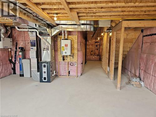 Unfinished basement with tankless water heater, heating unit, and a water softener - 261 Benninger Drive Unit# Upper, Kitchener, ON - Indoor Photo Showing Basement