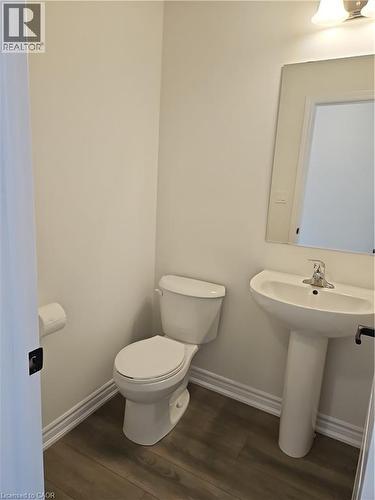 Half bathroom featuring baseboards and dark wood-style flooring - 261 Benninger Drive Unit# Upper, Kitchener, ON - Indoor Photo Showing Bathroom