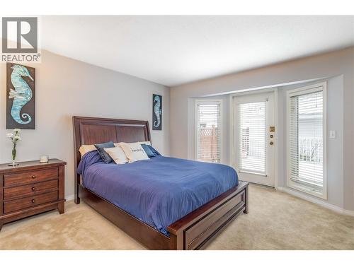 Primary suite with bright windows and access to back deck. - 1125 Keyes Road, Kelowna, BC - Indoor Photo Showing Bedroom