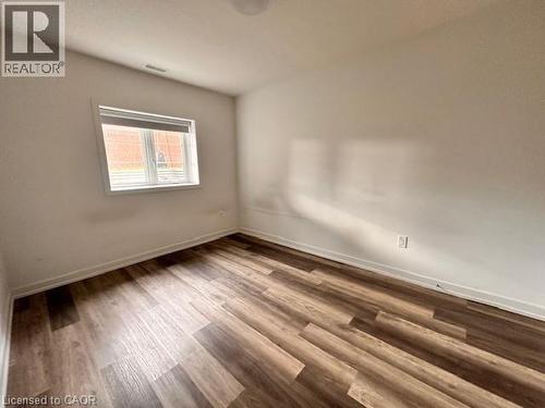 Unfurnished room featuring baseboards and wood finished floors - 205 West Oak Trail Unit# 66, Kitchener, ON - Indoor Photo Showing Other Room