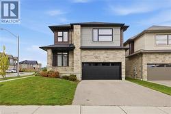 Contemporary home with a front yard, stone siding, asphalt driveway, and a garage - 