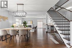 Dining area with a fireplace, dark wood-style flooring, a textured ceiling, stairway, and recessed lighting - 