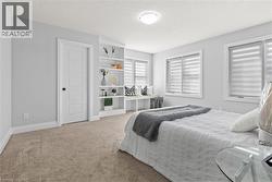 Bedroom featuring light colored carpet and a textured ceiling - 