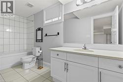 Full bath featuring light tile patterned floors, vanity, and washtub / shower combination - 