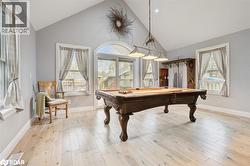 Recreation room featuring high vaulted ceiling, billiards, and light wood-type flooring - 