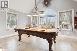 Rec room with plenty of natural light, pool table, light wood-type flooring, and high vaulted ceiling - 