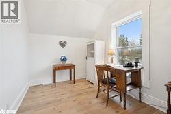 Office with light wood-style flooring and lofted ceiling - 