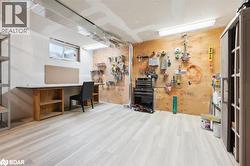 Miscellaneous room featuring light wood-style floors and a workshop area - 