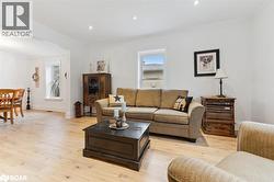 Living room featuring ornamental molding, light wood-style flooring, and recessed lighting - 