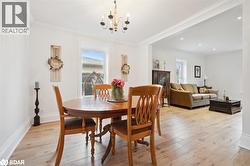 Dining space with plenty of natural light, light wood-style flooring, crown molding, and a chandelier - 