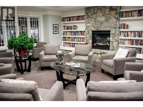 reading nook and many books and puzzles to borrow and share - 3897 Gallaghers Grange, Kelowna, BC - Indoor Photo Showing Living Room With Fireplace