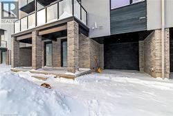 Snow covered property entrance with brick siding - 
