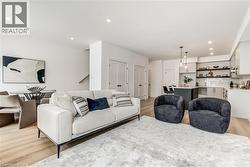 Living area with light wood-type flooring and recessed lighting - 