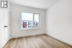 Unfurnished room with light wood-style floors and baseboards - 