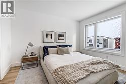 Bedroom featuring wood finished floors and baseboards - 