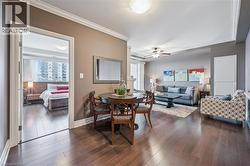 Dining area featuring crown molding, dark wood finished floors, and ceiling fan - 