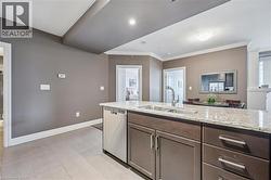 Kitchen featuring light stone counters, stainless steel dishwasher, dark brown cabinets, light tile patterned flooring, and ornamental molding - 
