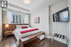 Bedroom featuring dark wood finished floors and baseboards - 