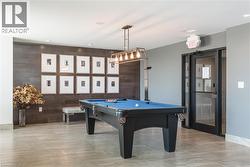 Rec room with billiards table, wood walls, and recessed lighting - 
