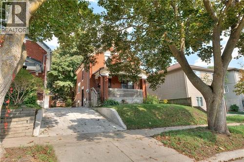 Obstructed view of property with a front yard, a porch, and brick siding - 50 Walnut Street, Kitchener, ON - Outdoor