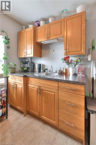 Kitchen featuring dark countertops, brown cabinets, and light tile patterned floors - 50 Walnut Street, Kitchener, ON - Indoor Photo Showing Kitchen