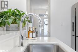 Kitchen view of stainless steel refrigerator with ice dispenser and a sink - 