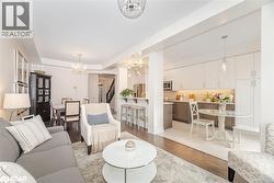 Living room with light wood-style flooring, stairs, and a chandelier - 
