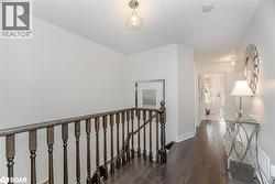 Hall with an upstairs landing, dark wood-style flooring, and a textured ceiling - 
