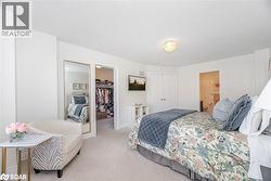 Bedroom with carpet, a walk in closet, a textured ceiling, and ensuite bathroom - 