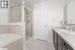Full bath featuring vanity, light tile patterned floors, a bath, and a stall shower - 