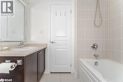 Full bathroom featuring vanity, light tile patterned floors, and washtub / shower combination - 