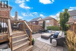 Wooden terrace featuring a fenced backyard, a patio, a residential view, an outdoor living space, and stairway - 