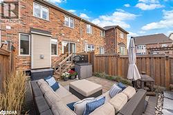 Fenced backyard with an outdoor hangout area, a wooden deck, a residential view, and a patio - 